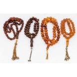 A collection of four amber type  bead necklaces, including two with round beads and gilt tassel
