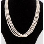 A multi row freshwater pearl necklace small oval shaped pearls approx 3mm, on a 9ct gold clasp