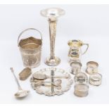 A collection of silver items to include: five variuos napkin rings, chased condiment spoon, Georgian