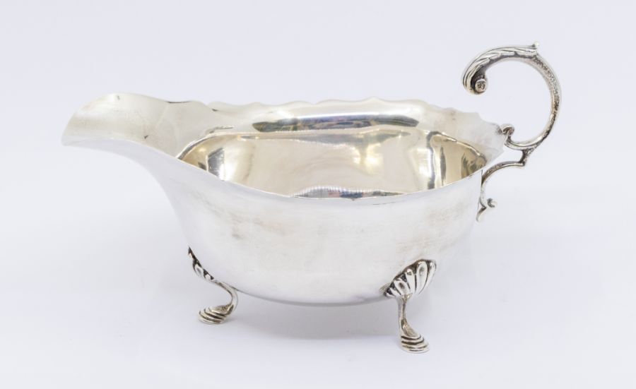 An George V silver sauce boat, plain bellied body with shaped rim, anthemion leaf thumb piece raised