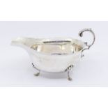 An George V silver sauce boat, plain bellied body with shaped rim, anthemion leaf thumb piece raised