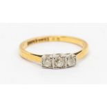 A 1930's diamond and 18ct gold three stone ring, comprising square platinum settings set with