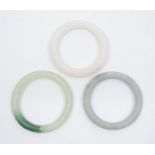 Three jadeite bangles, 20th century, one of pale celadon colour with green to one side, 7.7cm to 8cm