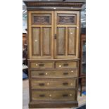 A late Victorian mahogany linen cupboard with two above three drawers, having two carved cupboard