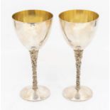 Stuart Devlin: a pair of Modernist silver goblets, planished bowls above textured floral tapering