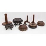 A collection of carved Asian stands and other carved mahogany circular plinths and plate stand (1