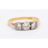 A diamond and 18ct gold three stone ring, comprising three old cut diamonds, the central stone