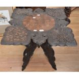 Carved mid 20th Century hard wood Indian table with leaf detail carved folding legs very ornate