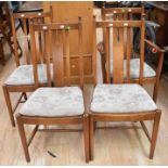 Four matching teak dining chairs, one of which is a carver