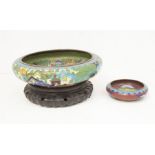 A Japanese cloisonne large circular bowl, decorated with figures in a village scene with rivers