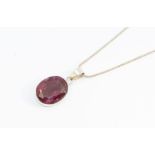A treated ruby and silver pendant oval, rub over set, measuring approx 17x20mm, approx 26 carats, on