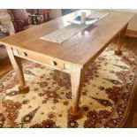 A 20th Century pine farmhouse table, single plank top over a single frieze end drawer, raised on