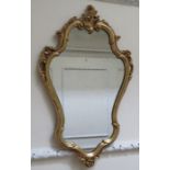 A  mirror in a gilt rococo style frame 87cm x 54cm good condition