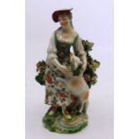 An 18th C Derby figure of a Shepherdess , patch marks to base , 14cm high Chips to the bocage .