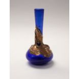 An Art Nouveau cobalt blue glass spill vase/bud vase, overlaid with sinuous copper decoration,