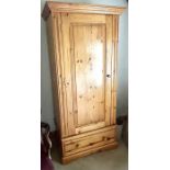 A 20th century pine wardrobe on a single chest. ***Offsite Location***