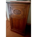 An early 20th century oak pot cupboard, slight oversailing top with a carved quarter gallery,