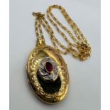 Glass filled ruby and diamond chip set locket. 8.5 grams approximately. 9ct gold on a 9ct gold