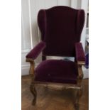 A Continental oak and walnut wing back armchair, 18th Century, upholstered in puce velvet, scroll