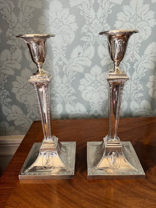 A pair of Adam style sterling silver weighted candlesticks, approximately 28 cms tall, in very