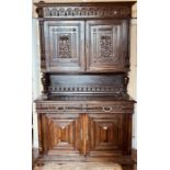 A 20th century oak dresser, moulded cornice above arch carved frieze, over twin panel carved