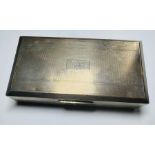 A hallmarked silver box, hinged, with engine turned lid. On the top is an inscription, H.B. and at