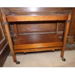 A Mid 20th C drinks trolley with Walnut vender patended " alternative table " measures 77cm long and