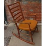 A 1970s rocking chair with a faux leather padded seat