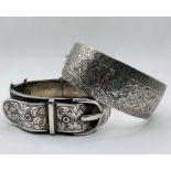 A pair of hinged bangles: one a Victorian style buckle hinged bangle, stamped STG, gross weight