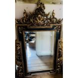 A Victorian style century gilt and ebonised wall mirror, in an inverted rectangular frame, scrolling