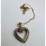 A 375 stamped yellow metal heart pendant set with approx 1/2 carat of round brilliant cut diamonds