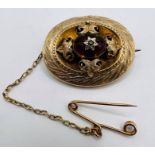 A Victorian Garnet mourning brooch, with an ornate foliate setting, featuring a carved garnet