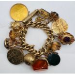 A 9ct heavy gold charm bracelet suspending numerous charms including a 14k medallion and a 100