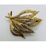 A textured foliate yellow metal mid 20th century brooch, stamped 585 with "MP" makers mark. Gross