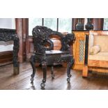 An Oriental ebonized hardwood open armchair, the back, arms and cabriole legs carved with dragons