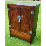 A Chinese hardwood cabinet with a pair of panelled doors enclosing cupboard above deep shaped apron,