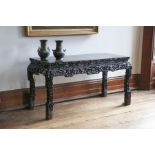 A Chinese ebonized and carved hardwood altar table, late 19th century, the plain plank top above