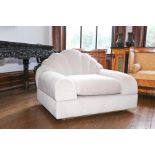 An Art Deco style low armchair with fawn coloured upholstery cloud back, the seat with loose