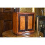 A Victorian mahogany table top cabinet with a pair of panelled doors enclosing an arrangement of