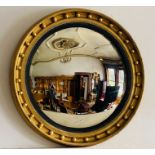 A large Regency style convex wall mirror with reeded ebonized fillet, the moulded frame applied with