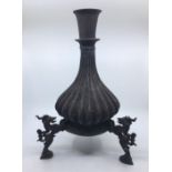 A 19th century Sino-Tibetan bronze vase, raised upon three Qilin (Kirin) supports, height 39.5cm.