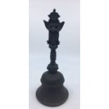 A 20th century Indian bronze bell, with cast deity terminal, height approx. 24cm.