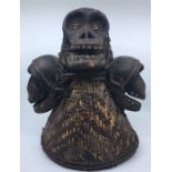 A late 20th century tribal figure, woven cane with carved softwood skulls and cowrie shell eyes,