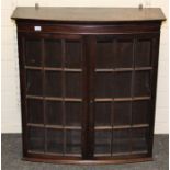 An Edwardian mahogany wall mounting collector's cabinet of slight bow front form, having a pair of