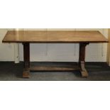 An early 20th century oak refectory dining table, the planked top on twin chamfered end supports and