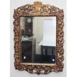 A 19th century carved giltwood wall mirror, the frame with flower basket, cherub and pierced