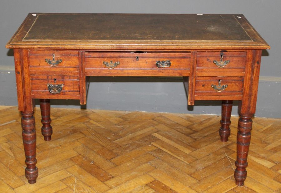 An Edwardian mahogany and beech writing desk, the rectangular top over single long and four short