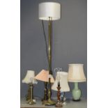 An early 20th Century brass standard lamp, reeded column support on circular base with paw feet