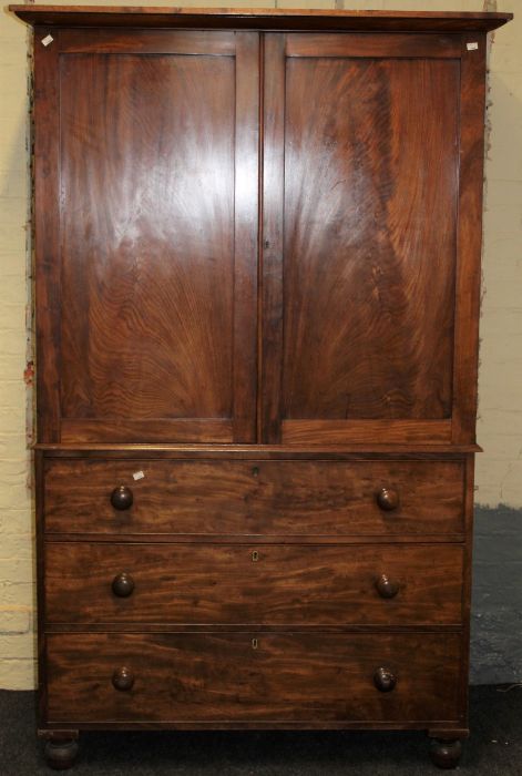 A 19th century mahogany linen press, the moulded cornice over a pair of panel doors enclosing four