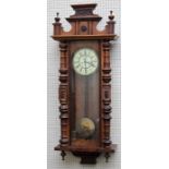 A late 19th century walnut cased Vienna wall clock, twin train movement striking upon gongs, faced